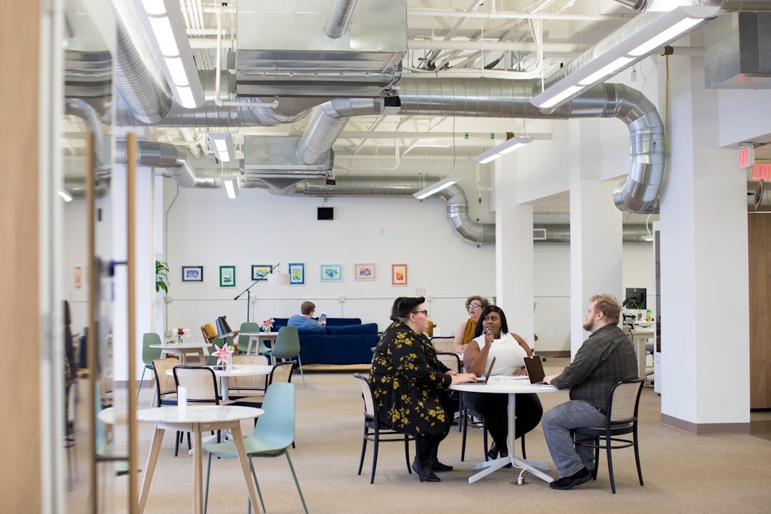 Colleagues collaborating around a laptop in an open office