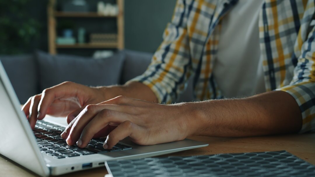 Person typing on a laptop keyboard at a desk